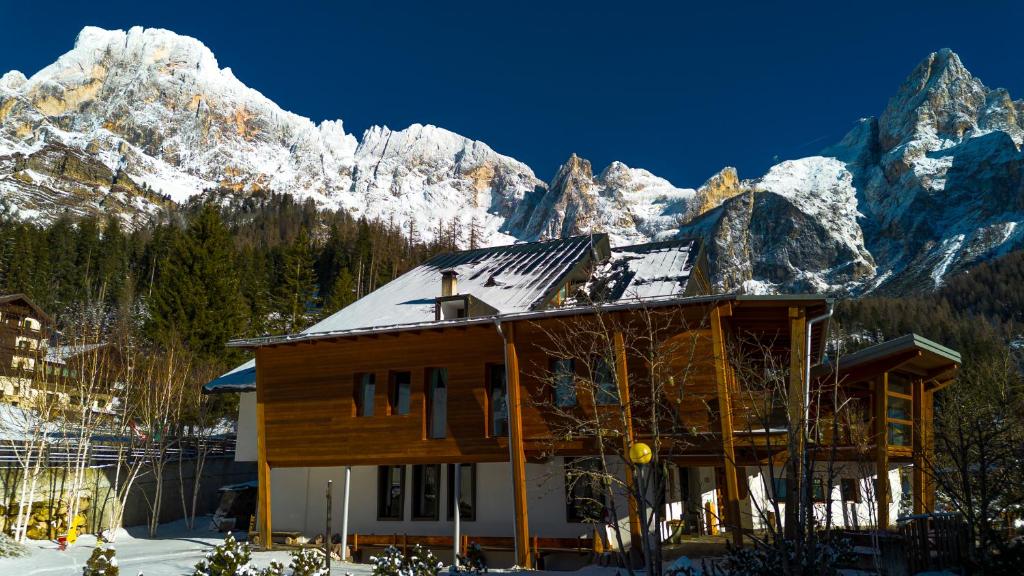 ein Gebäude mit schneebedeckten Bergen im Hintergrund in der Unterkunft Hotel Paladin in San Martino di Castrozza