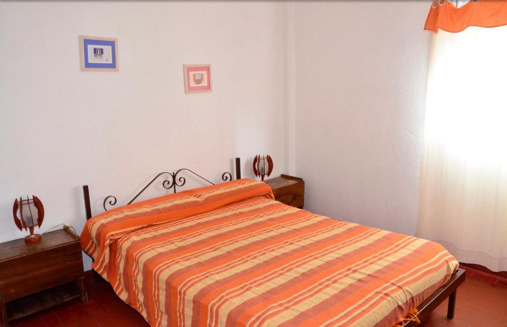 サンタ・テレシータにあるLo de Carlosのベッドルーム1室(オレンジ色のストライプ毛布付きのベッド1台付)