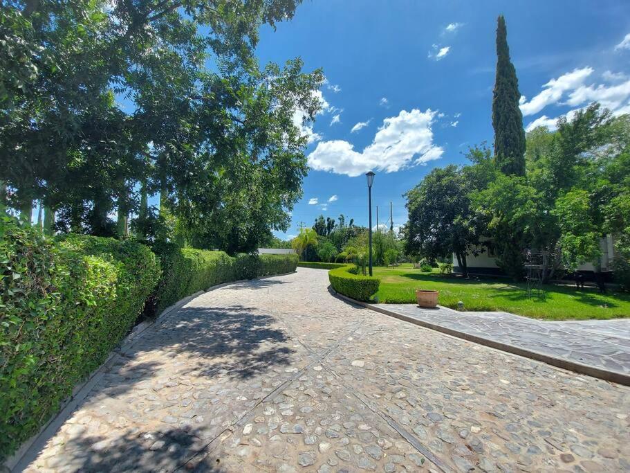 une passerelle dans un parc avec des buissons et des arbres dans l'établissement Quinta Luz de Luna, à Parras de la Fuente