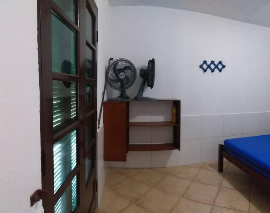 a room with a door and a fan on the wall at Casa em Iguape praia da Juréia in Iguape