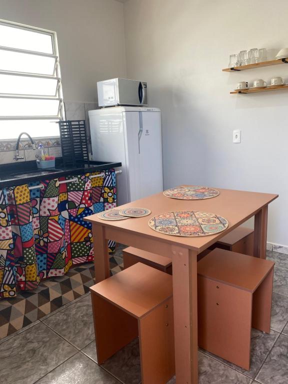 a kitchen with a table and a refrigerator at Apartamento cachoeira in Florianópolis