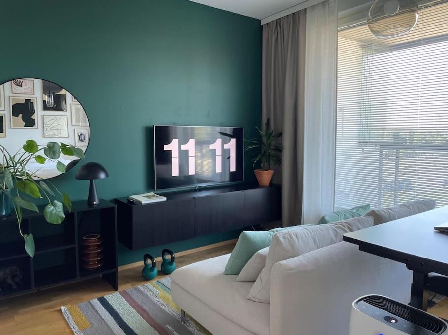 - un salon avec un canapé blanc et une télévision dans l'établissement Cozy Top-Floor Studio in Turku - Near City Center, à Turku