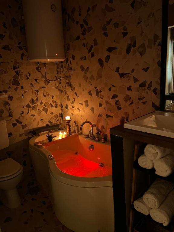 een badkamer met een rood bad met een kaars erin bij Banja Luka CITY2 in Banja Luka