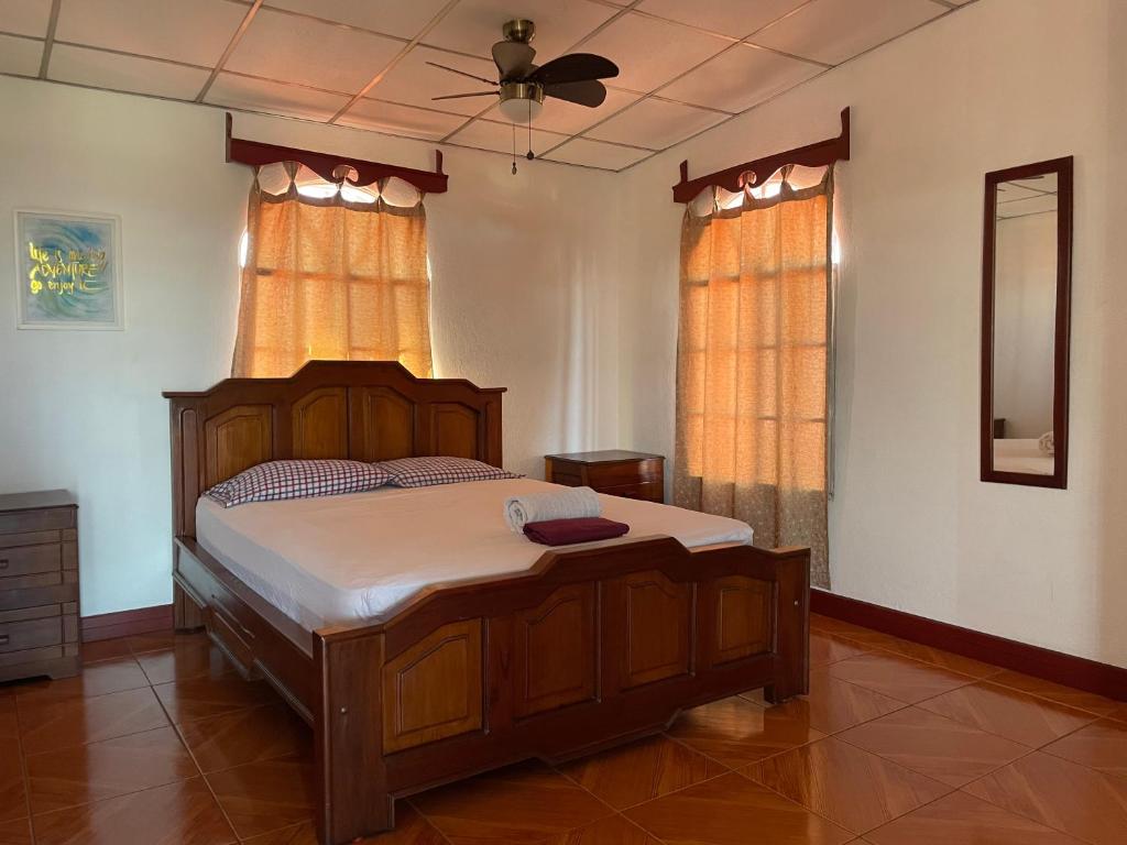 a bedroom with a wooden bed and a ceiling fan at Casa Martin in Managua
