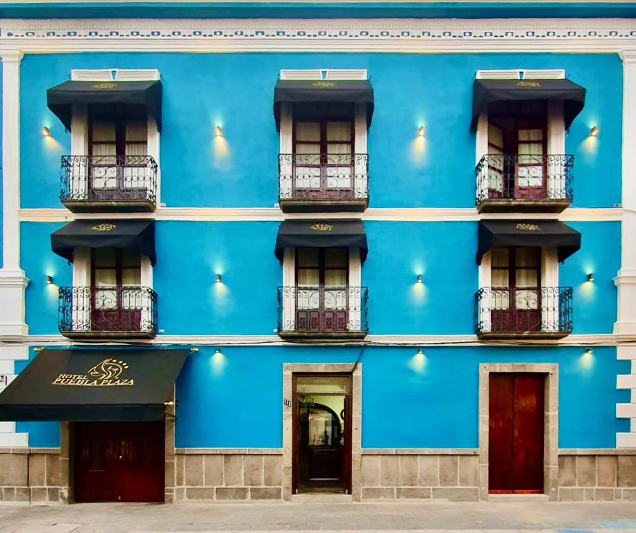 fachada azul de un edificio con ventanas en Hotel Puebla Plaza, en Puebla