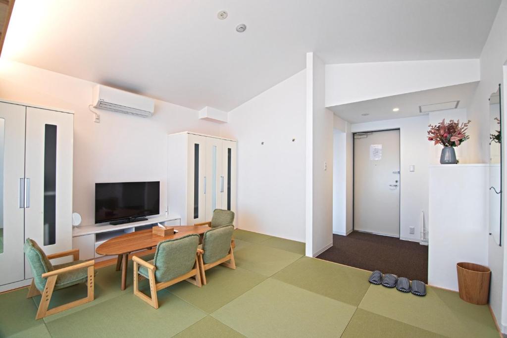 a living room with a table and chairs and a television at KyotoGosyonishi - Vacation STAY 23009v in Kyoto