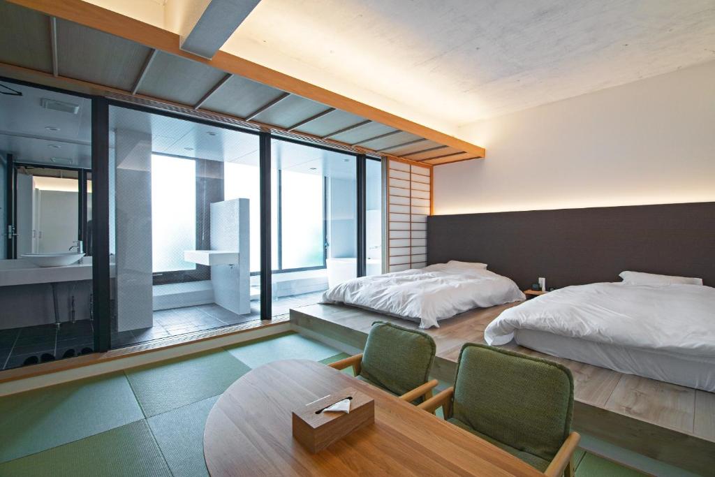 1 dormitorio con 2 camas, mesa y sillas en KyotoGosyonishi - Vacation STAY 22999v en Kyoto