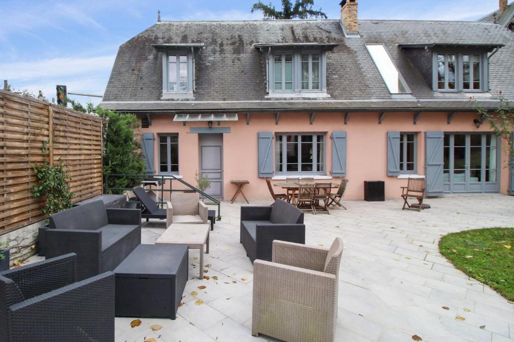 a patio with furniture in front of a house at Charming house with garden in Sèvres - Welkeys in Sèvres