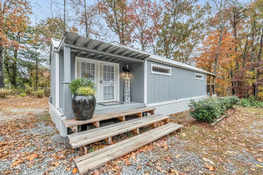 een tiny house met een veranda en een vaas bij Cottage Core Farmstay @ the TINY HOME in Trenton