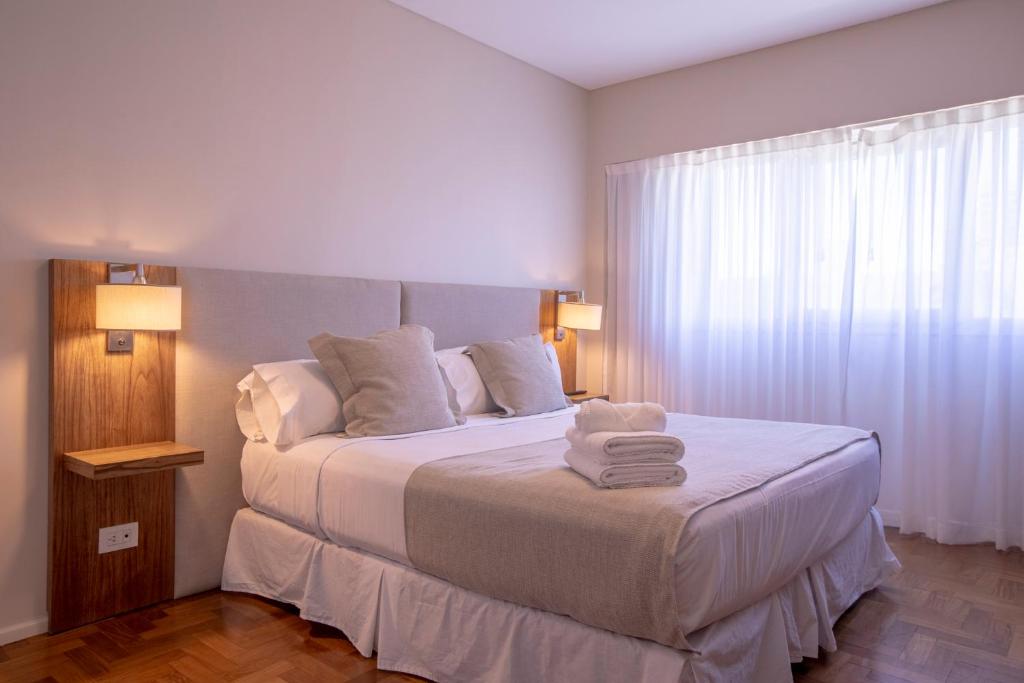 1 dormitorio con 1 cama con toallas en El Misti Coliving Obelisco en Buenos Aires