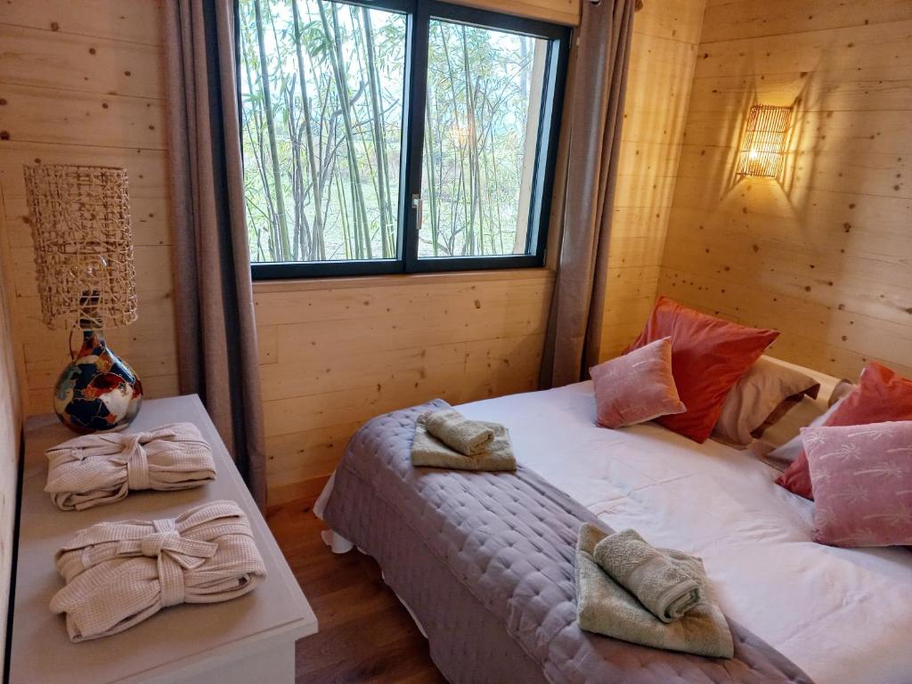 1 Schlafzimmer mit 2 Betten und einem Fenster in der Unterkunft maisonette et spa bois in La Bégude-de-Mazenc