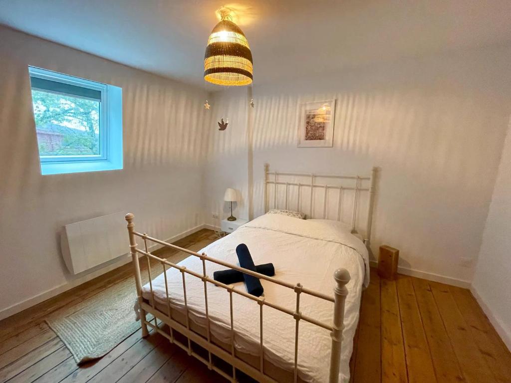 1 dormitorio con cama, lámpara y ventana en ღ Fabrik • Parking sécurisé & Wifi fibre, en Douai
