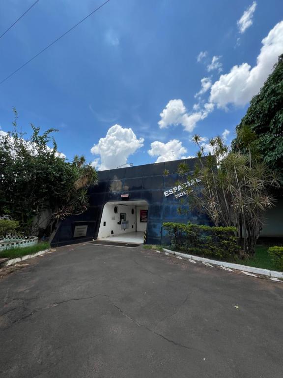um parque de estacionamento com uma garagem branca em frente a um edifício em Espacial Motel em Araçatuba