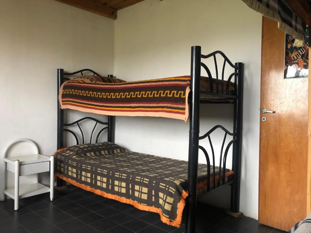 2 stapelbedden in een kamer met een deur bij Bereber Hostel in Santa Clara del Mar