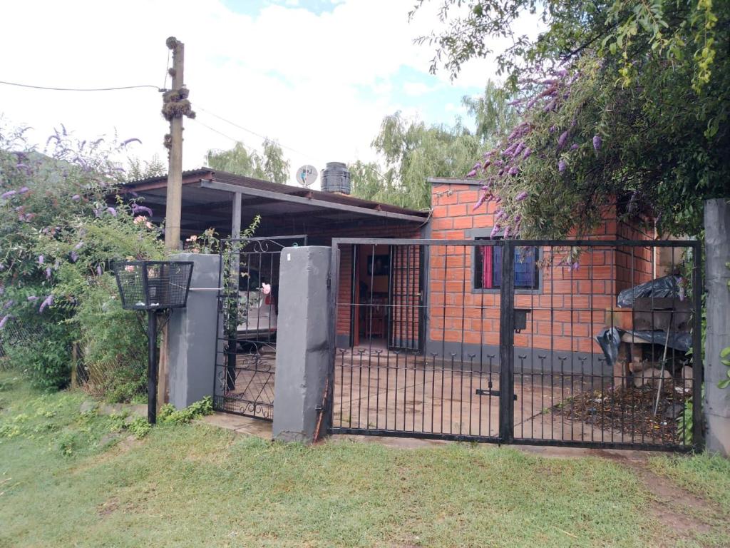 a fence with a gate in front of a house at CASA EN TAFI DEL VALLE ZONA LA ANGOSTURA in San Miguel de Tucumán