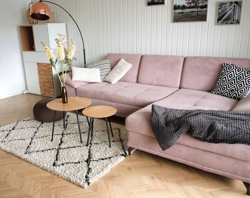 ein Wohnzimmer mit einem rosa Sofa und einem Tisch in der Unterkunft MILANA Naturpanorma, ruhig & familienfreundlich in Winterberg