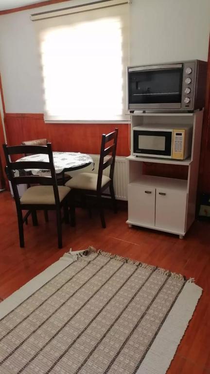 a living room with a television and a table and chairs at Apartamento 410 in Punta Arenas