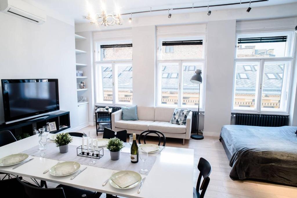 una sala de estar con una mesa y un sofá en Stunning new central home near Basilica, en Budapest