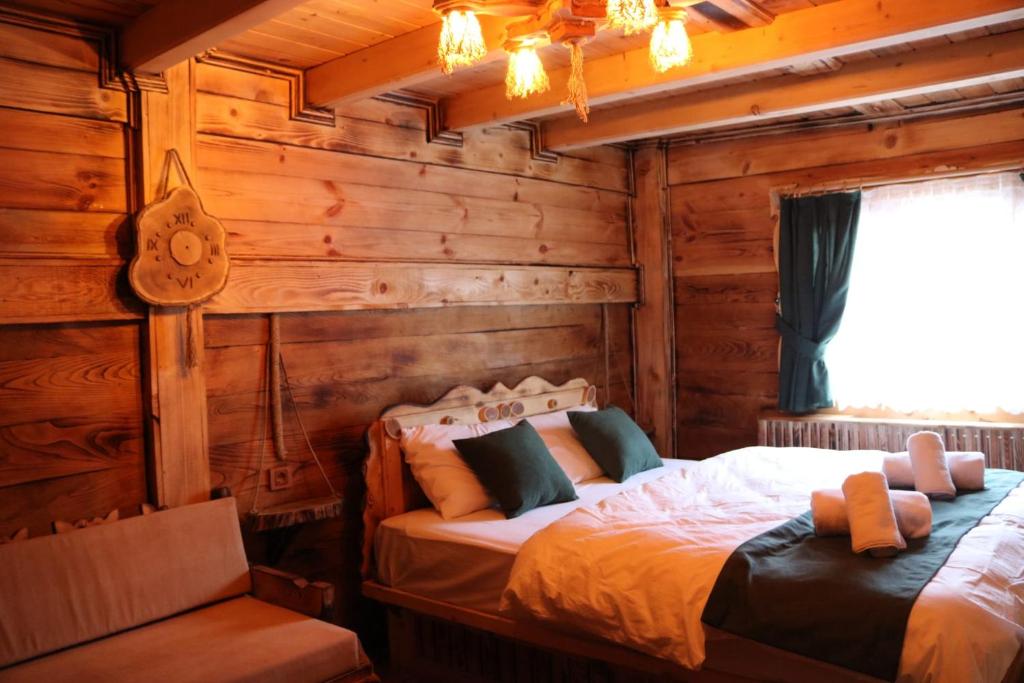 twee bedden in een kamer met houten wanden en een raam bij RUBAŞI OTEL FINDIKLI 
