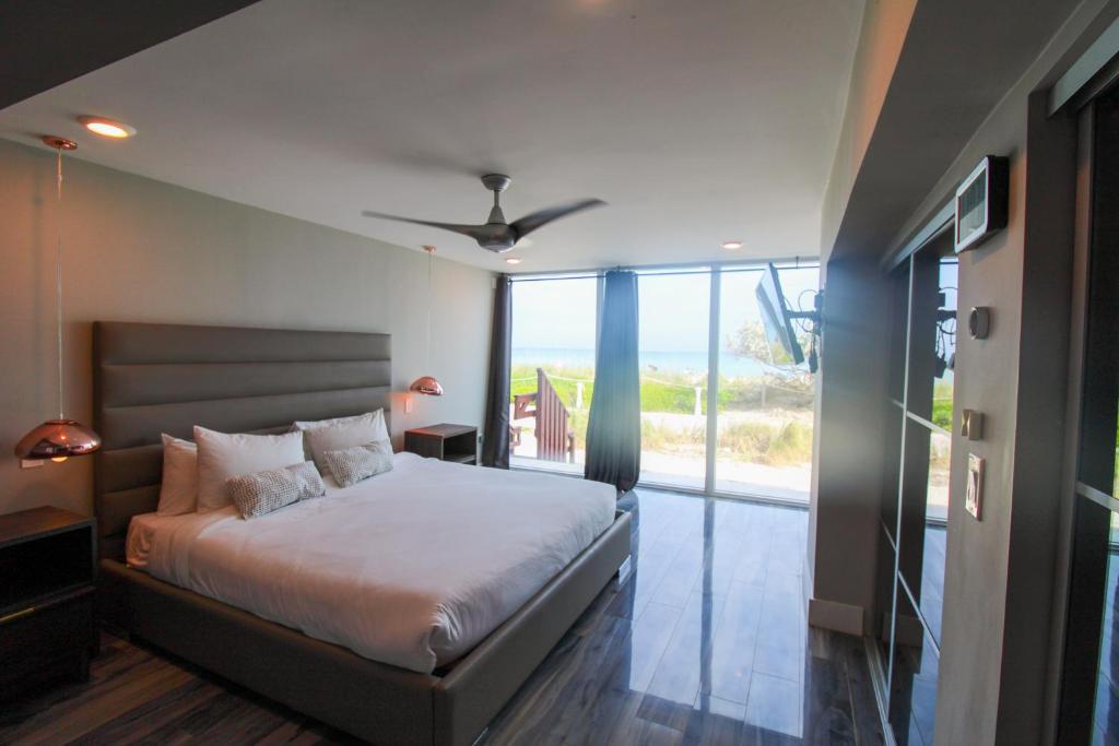 a bedroom with a bed and a large window at Castle BTH2 Stunning Oceanfront Townhouse, Private Beach Access, Private Pool Access, Tennis and Free Parking! in Miami Beach