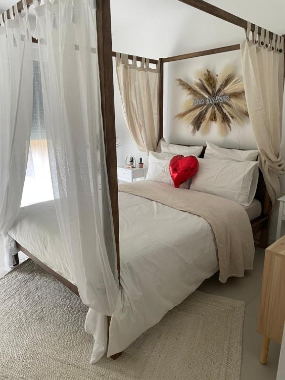 una camera con letto a baldacchino con cuore rosso di La Gabriela a Tournon-sur-Rhône