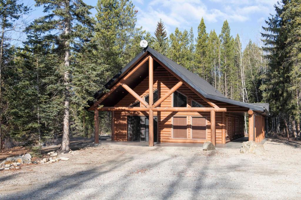 a log cabin in the middle of a forest at Grizzly Den in Valemount