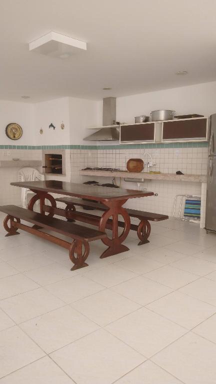 uma cozinha com uma mesa de madeira em Casa com 6 suítes e piscina, a 160m da praia em Florianópolis