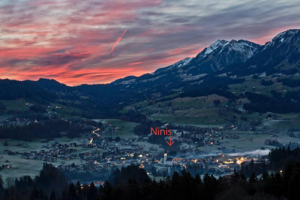 a town in a valley at sunset with mountains at Ninis - Ferienhaus im Bregenzerwald in Egg