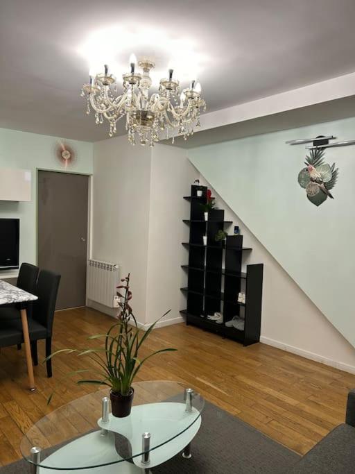 un salon avec un lustre et un escalier dans l'établissement Maison conviviale, à Villejuif