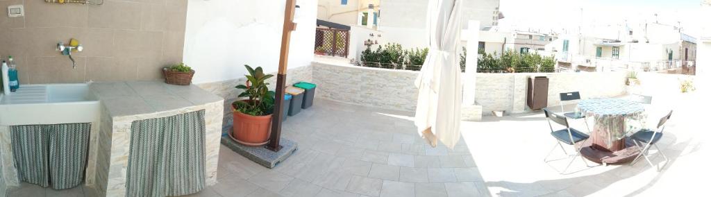 een balkon met een badkamer met een wastafel en een tafel bij Camera Brupier in Ruvo di Puglia