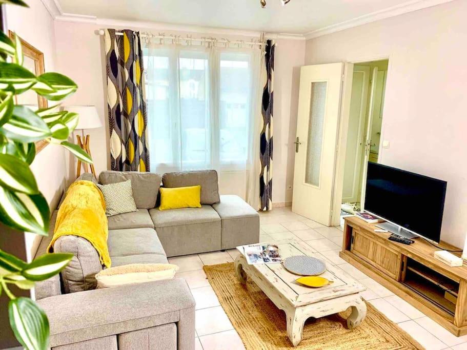 un salon avec un canapé et une télévision dans l'établissement Maison 3 ch. Garage, jardin, 10 min circuit, au Mans