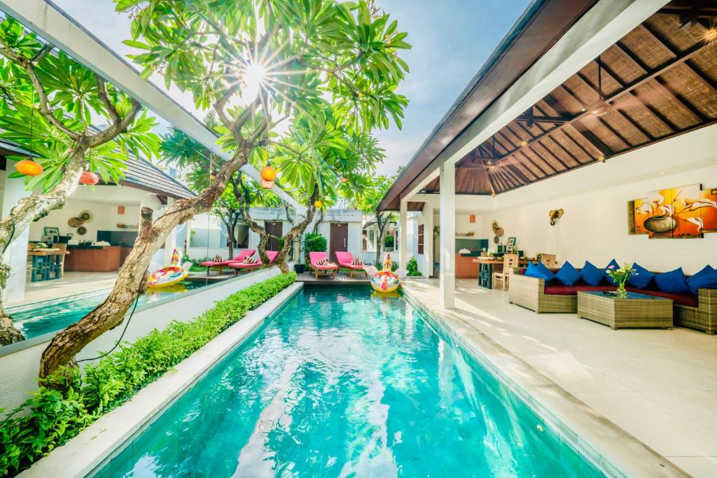 an indoor pool with palm trees in a house at Villa Olli with Private Pool in the Heart of Seminyak - Free WI-FI and Netflix in Seminyak