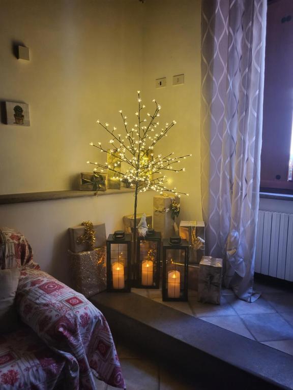 A casa di Grazia في فيتورشيانو: غرفة بها شجرة عيد الميلاد مع الشموع المضاءة