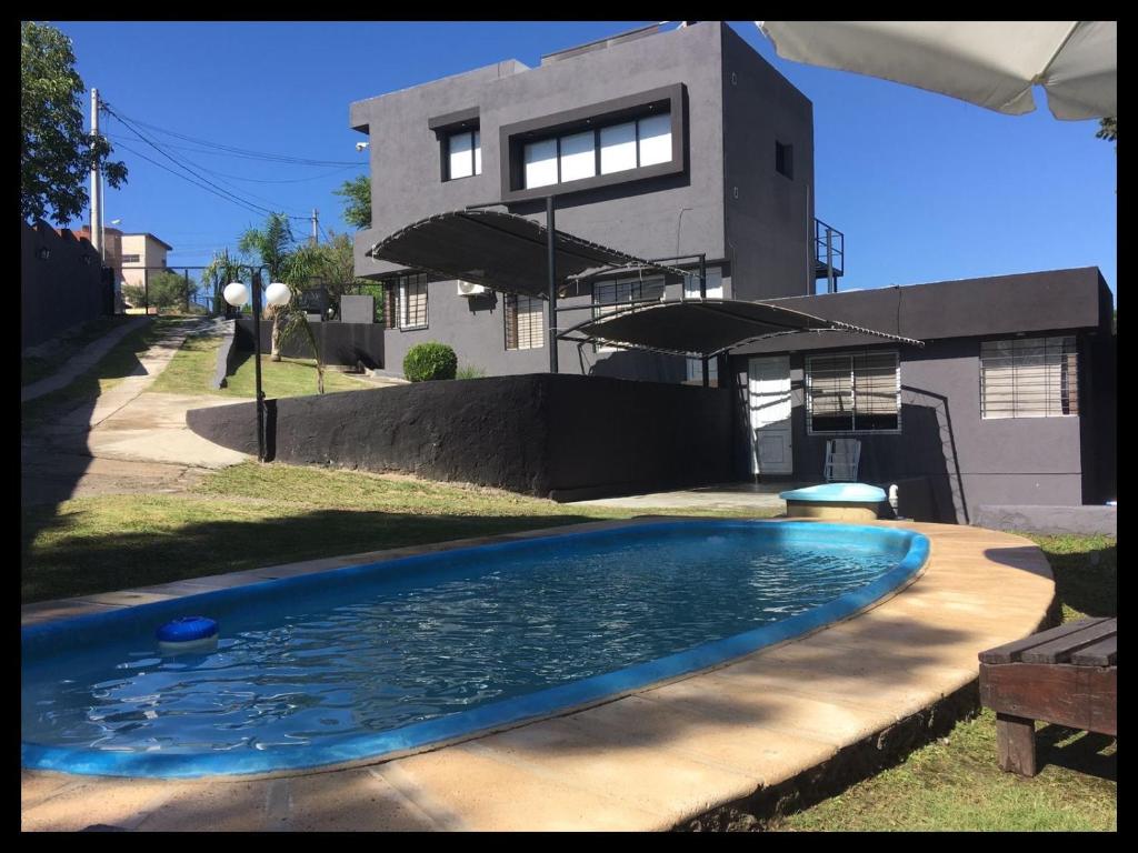 una piscina frente a una casa en AMSTERDAM DEPARTAMENTOS en Villa Carlos Paz