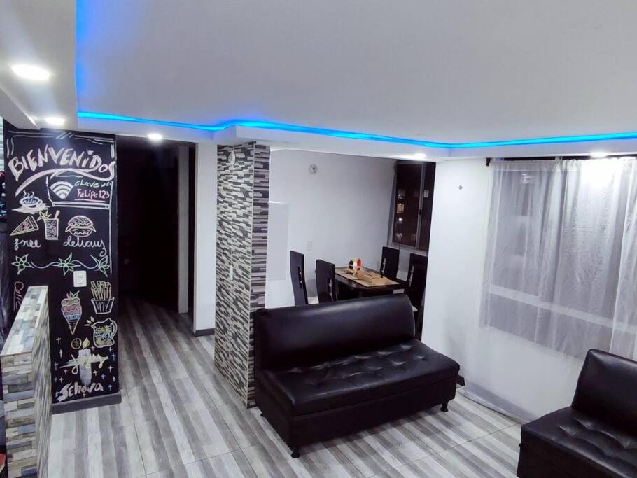 Precioso apartamento completo con tina y equipado في Soacha: غرفة انتظار مع كرسي جلد أسود وطاولة