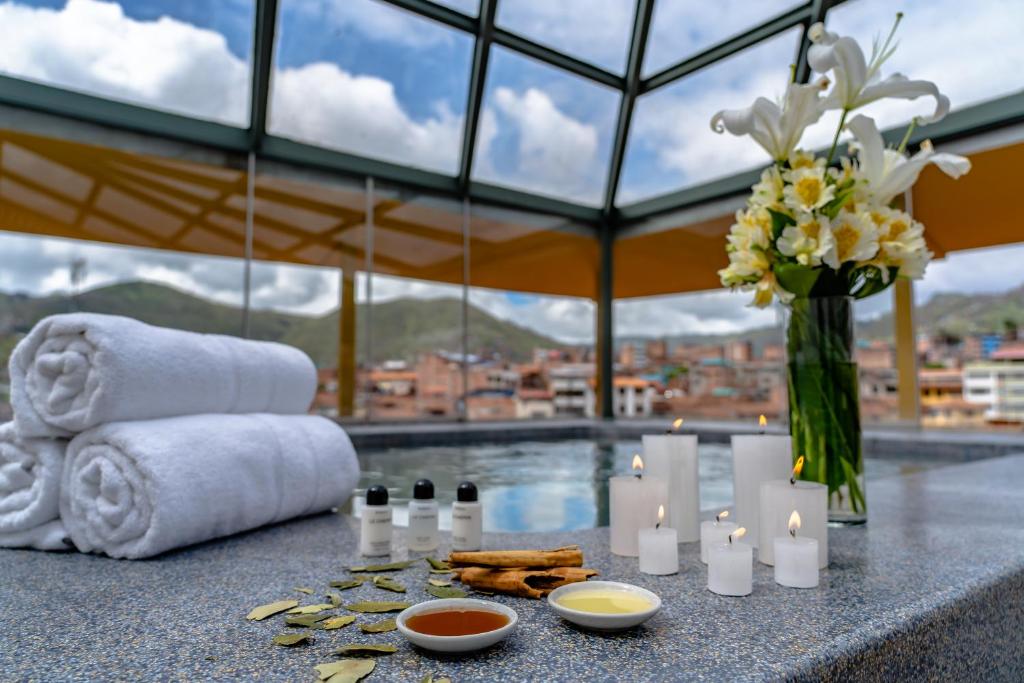 a table with candles and towels and a vase of flowers at Hotel Jose Antonio Cusco in Cusco