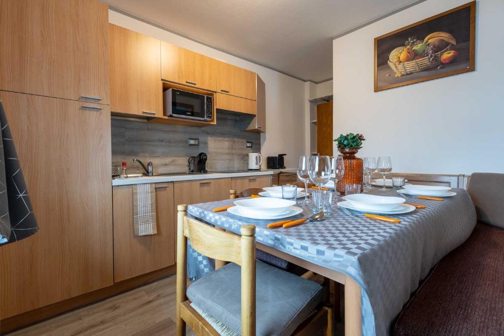 una cocina con una mesa con platos y vasos. en Vision Apartment - Livigno, en Livigno