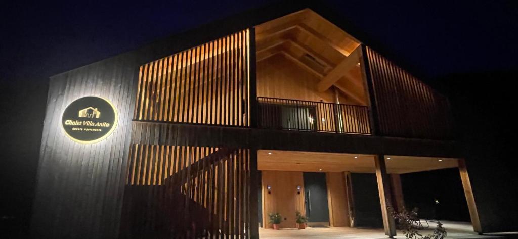 a building with a sign on the side of it at night at Villa Anita Chalets in Valle Di Casies