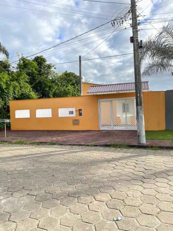 a yellow building with a pole in front of it at Paraíso Particular in Itanhaém