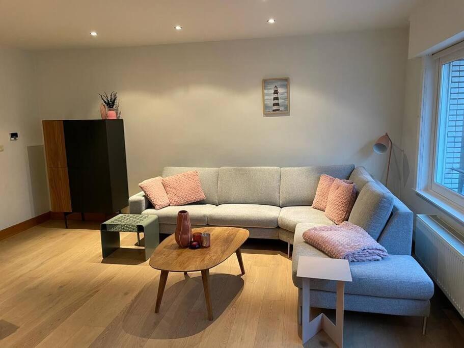 uma sala de estar com um sofá e uma mesa em Apartment Testerep in Westende-Bad 150 m van het strand met garage voor 5 personen em Middelkerke