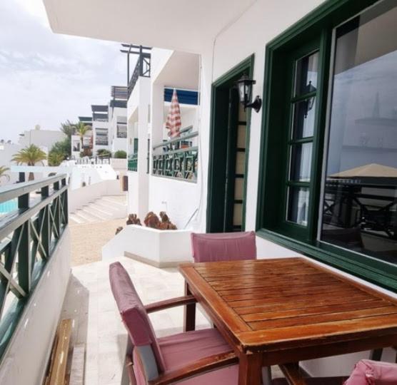a wooden table and chairs on a balcony at 118 Portonovo in Puerto del Carmen