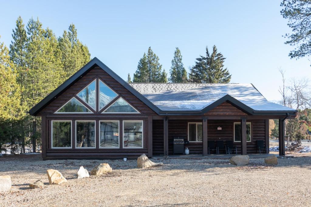 a log cabin with windows and rocks in front of it at Summit View in Valemount