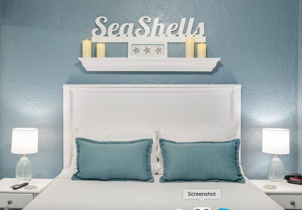 a white bed with two pillows and a sign above it at Seashells Getaway in Marathon