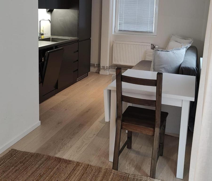 a small kitchen with a white table and a chair at 2- bed Apartment in Sollentuna in Sollentuna