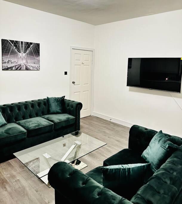 sala de estar con 2 sofás y TV de pantalla plana en Luxurious & modern large house 9mins drive to town en Beeston Hill