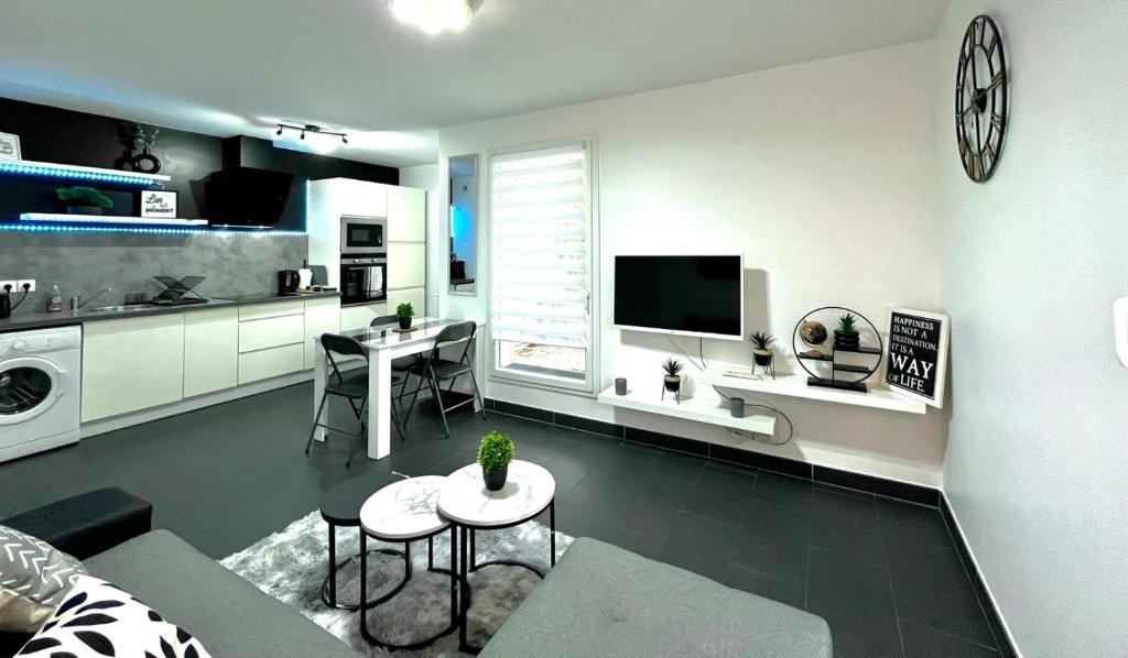 uma sala de estar com um sofá, uma mesa e uma cozinha em GRAND F2 A 5 MIN A PIEDS DE LA GARE em Vigneux-sur-Seine