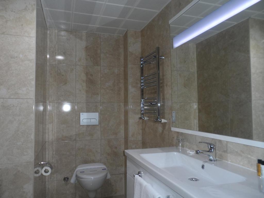 W łazience znajduje się umywalka, toaleta i lustro. w obiekcie Zen Inn Boutique w mieście Şarköy