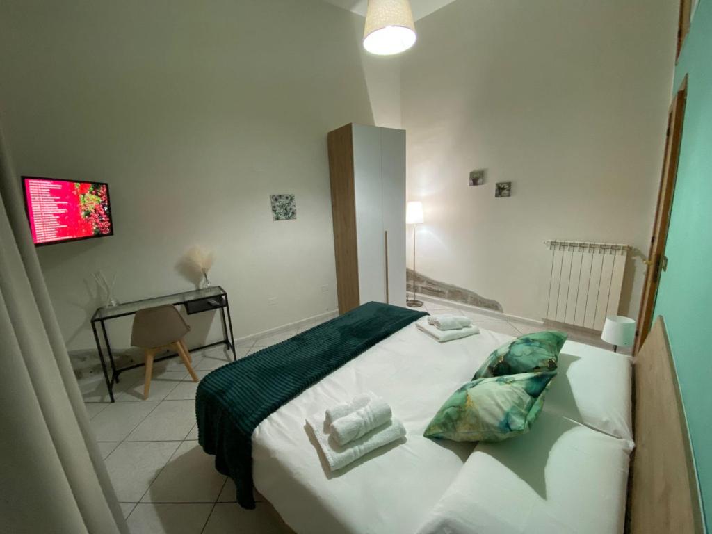 una camera con letto con cuscini e scrivania di Nalusa Home a Sarno