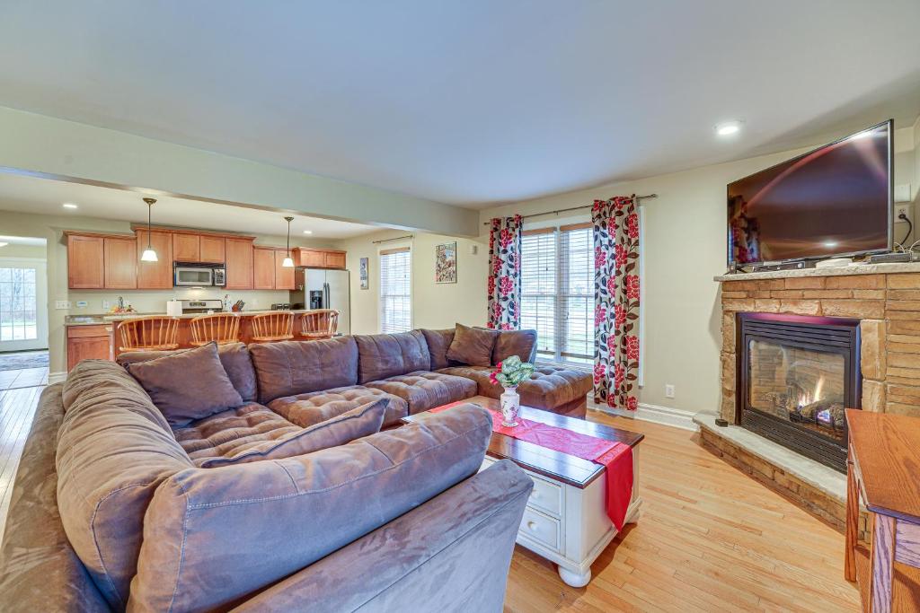 a living room with a couch and a fireplace at Ellicottville Townhome with Hot Tub about 2 Mi to Skiing in Ellicottville