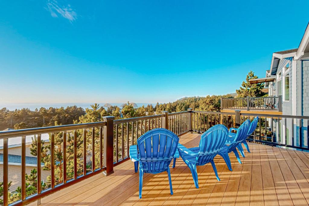 three blue chairs on a deck with a view of the water at Ocean Crest Panoramic Vistas in Oceanside
